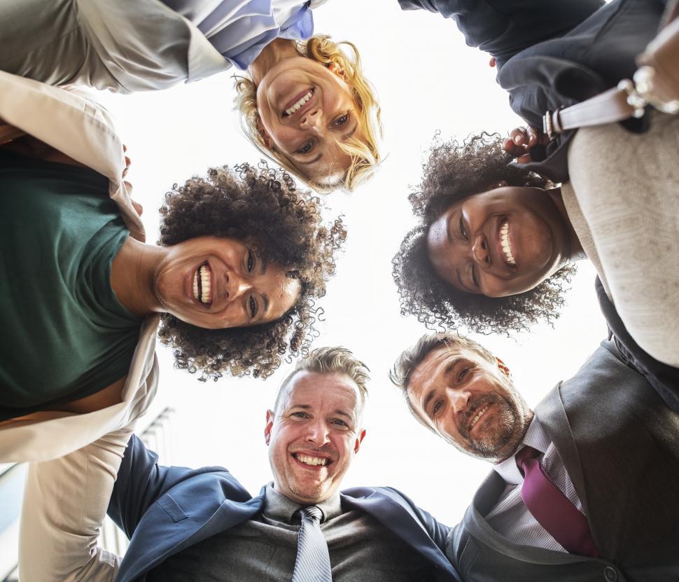 Free Image of Low angle view looking up at a team huddle of happy colleagues  