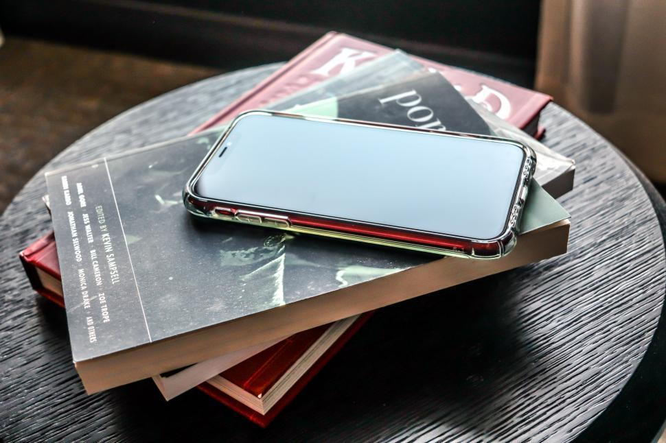 Free Image of Phone on top of books, on a table 