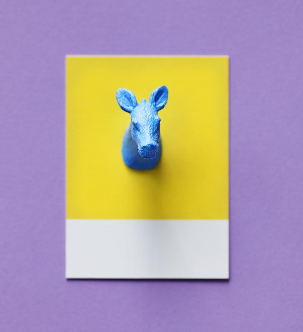 Free Image of Flay lay of a miniature toy donkey s head on a spaced cardboard frame 