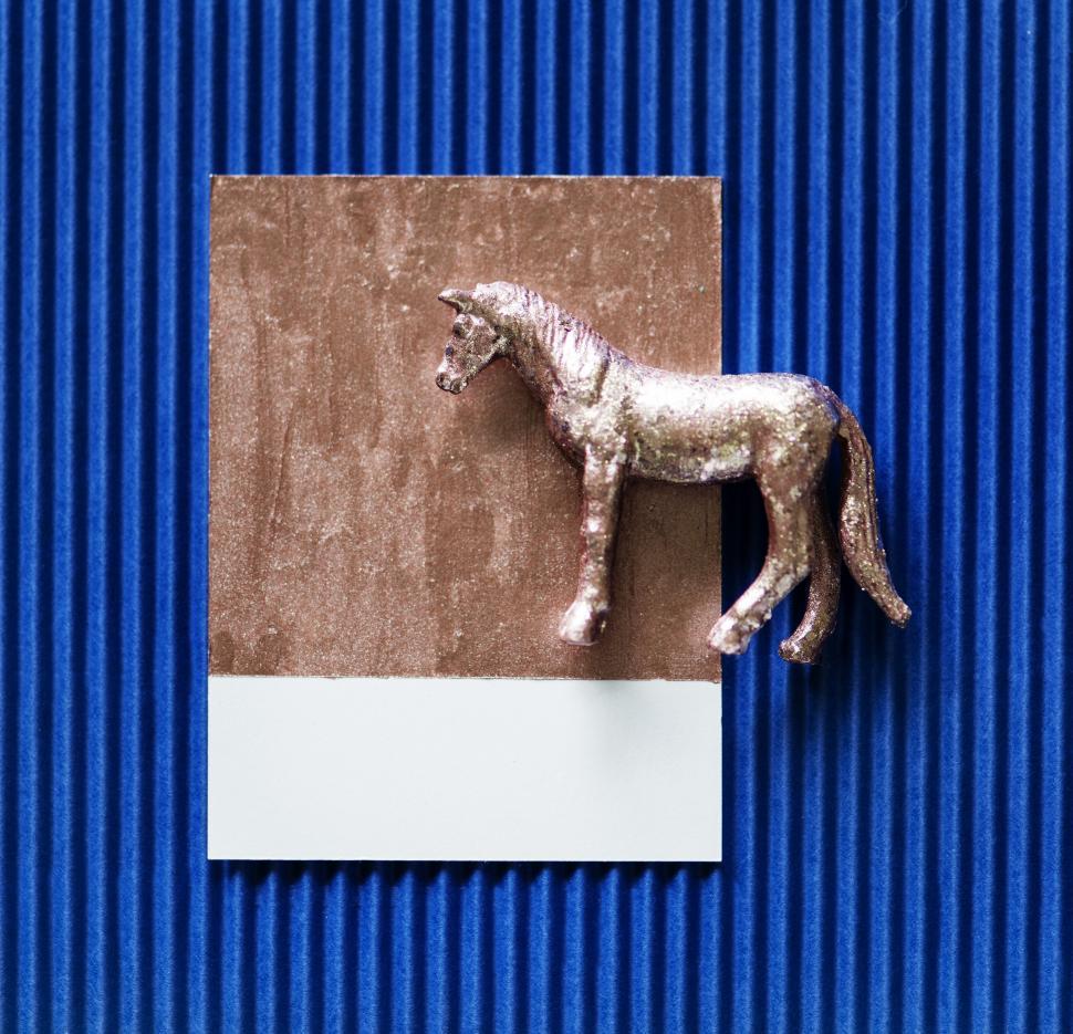 Free Image of Flay lay of a miniature glittery toy horse on a spaced cardboard frame 