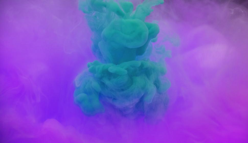 Free Image of Smokey green and magenta ink swirling in water 