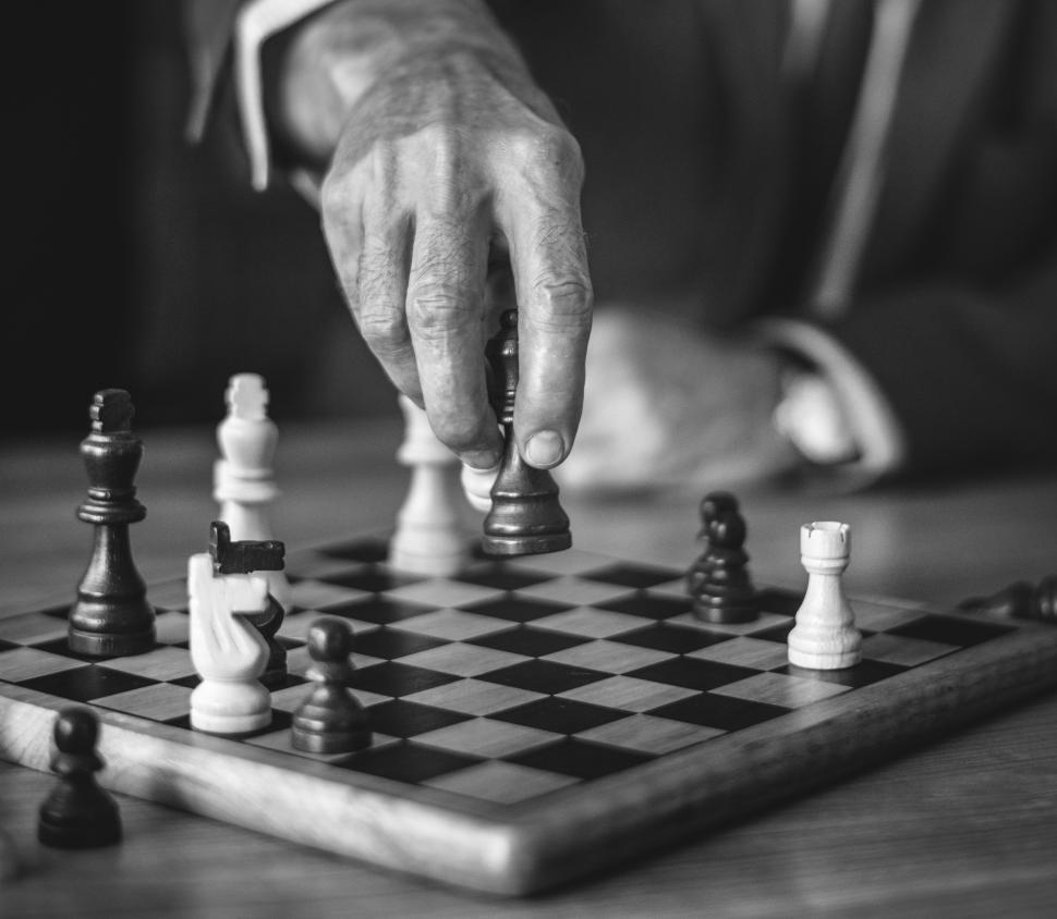 Free Image of Close up of a hand playing chess in black and white 