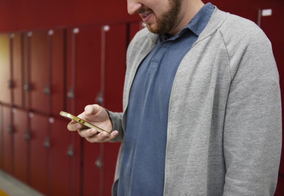 Free Image of A bearded man looks at his mobile phone 
