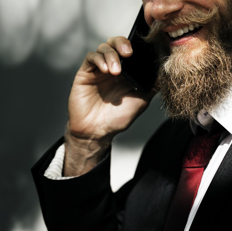 Free Image of A smiling bearded man speaking on the mobile phone 