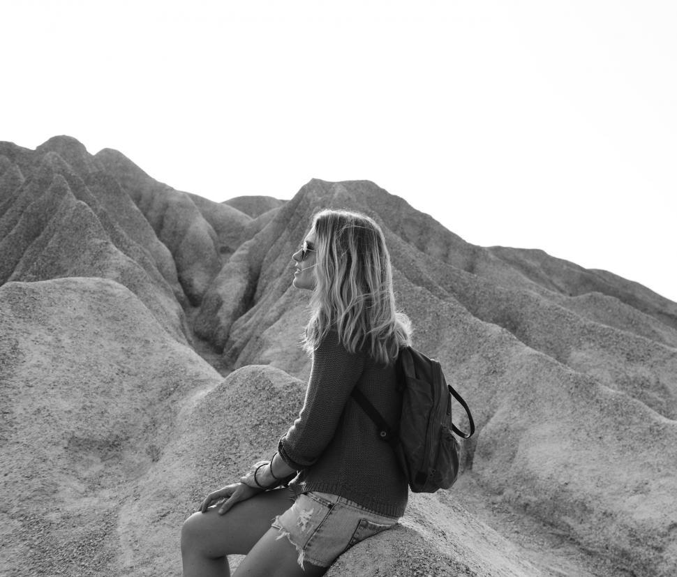 Free Image of A young caucasian woman sits on a rock 