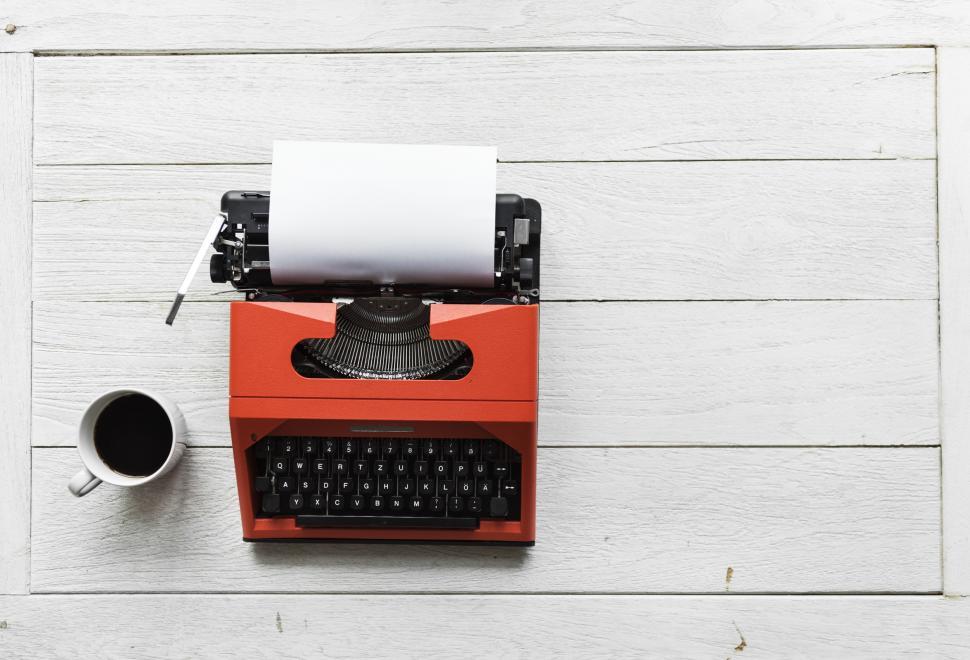 Free Image of Flat lay of a red typewriter and a coffee mug 