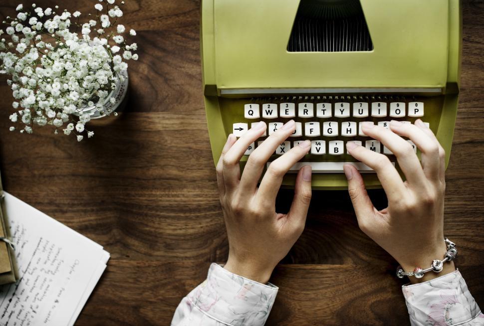 Free Image of Overhead view of hands typing on a green vintage typewriter 