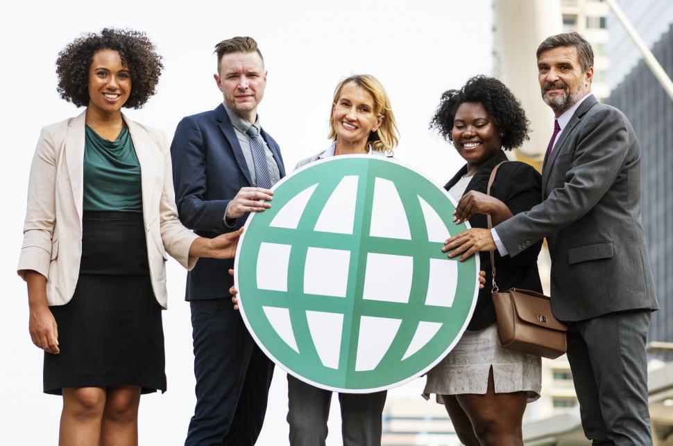 Free Image of Colleagues posing with a globe symbol cardboard cutout 