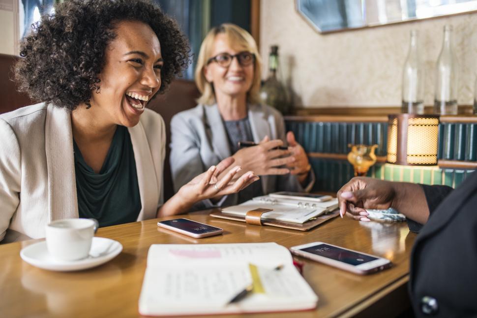 Free Image of Multiethnic Coworkers laughing at a cafe table 