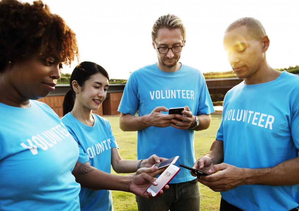 Free Image of A group of multiethnic volunteers looking at their mobile phones 