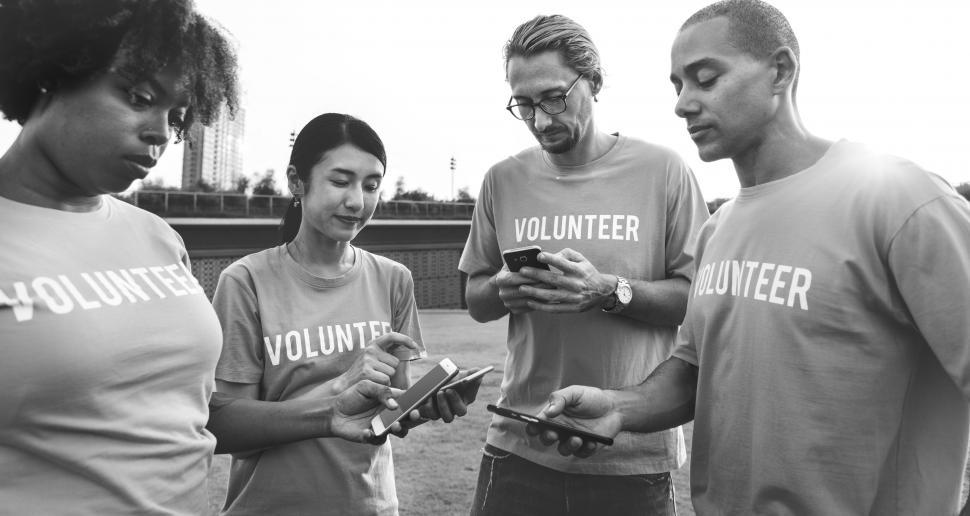 Download Free Stock Photo of Black and white photo of volunteers looking at their mobile phones 