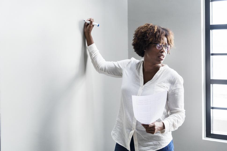 Free Image of A woman writing on the board in a meeting 