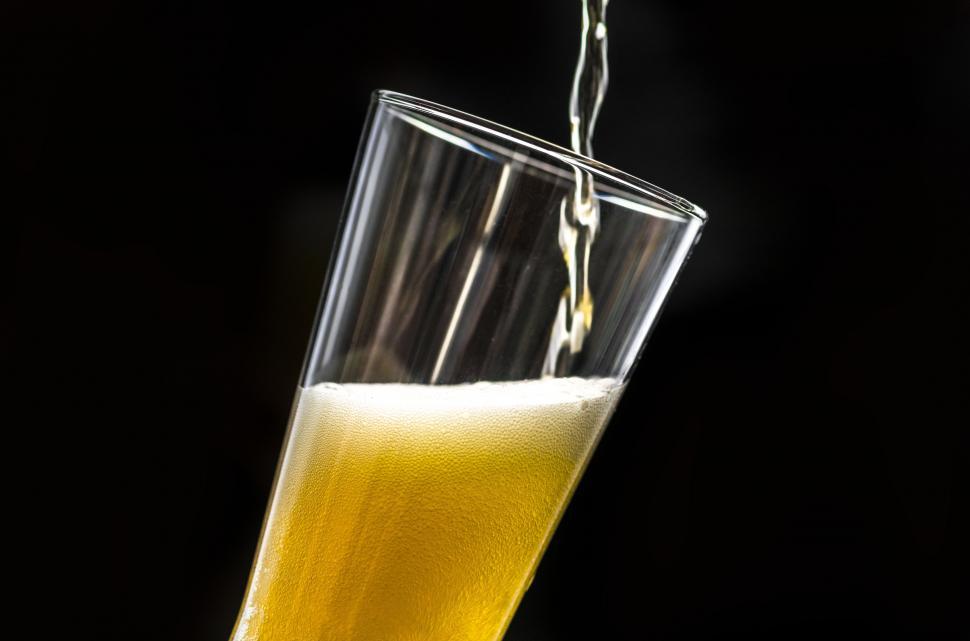 Free Image of Beer being poured into a tilted pint glass 