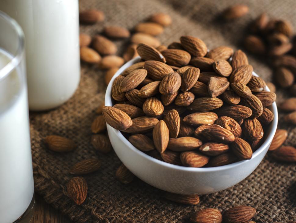 Free Image of Close up of almonds alongside a glass of milk 