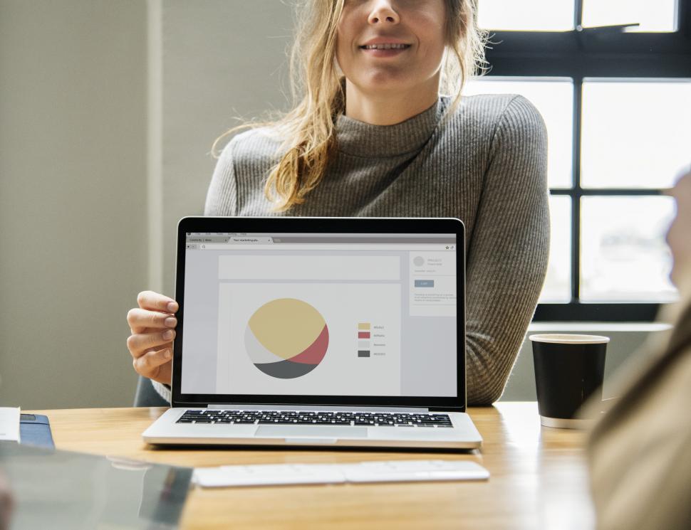 Free Image of A young Caucasian woman pointing at a laptop with unusual chart 