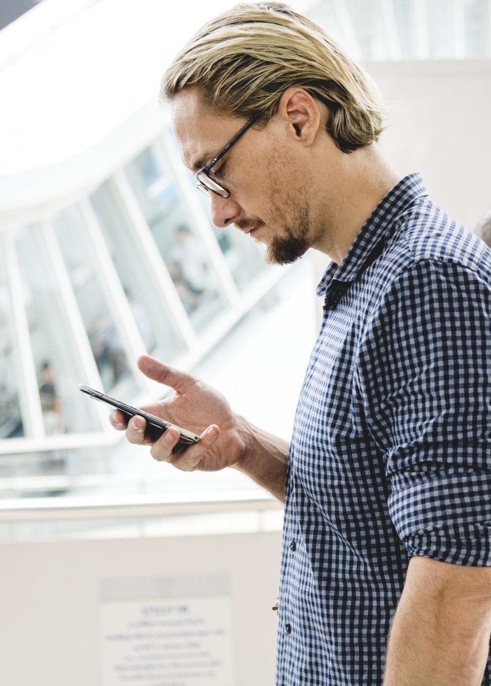 Free Image of A bearded Caucasian man looking at his mobile phone 