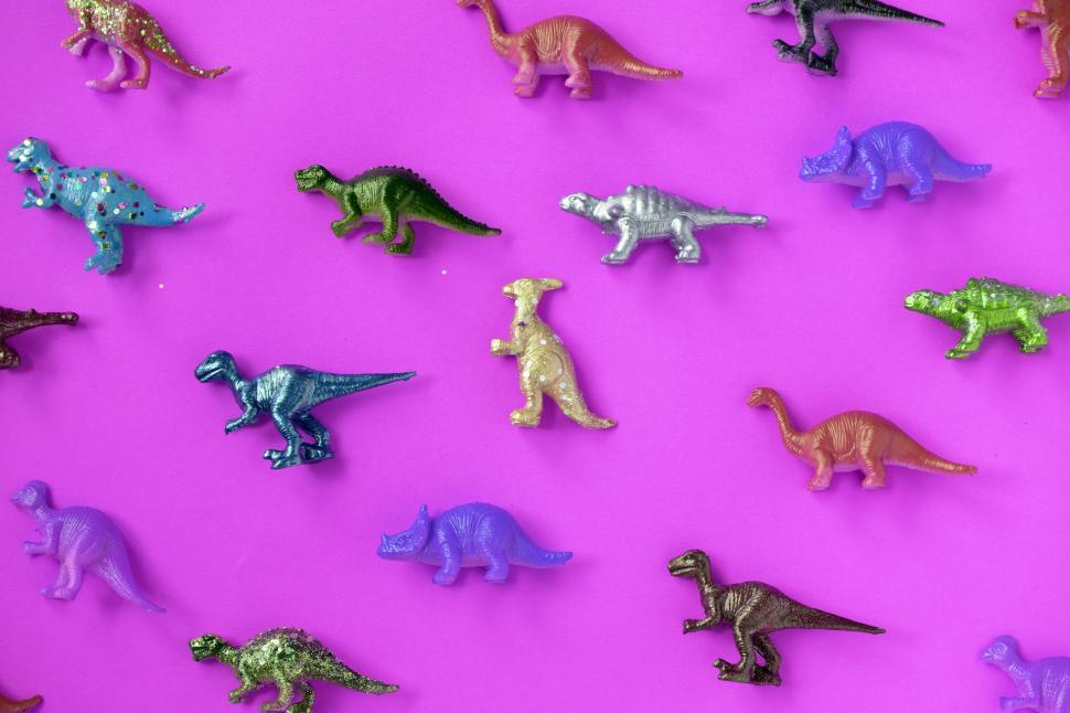 Free Image of Colorful toy dinosaurs on magenta surface 