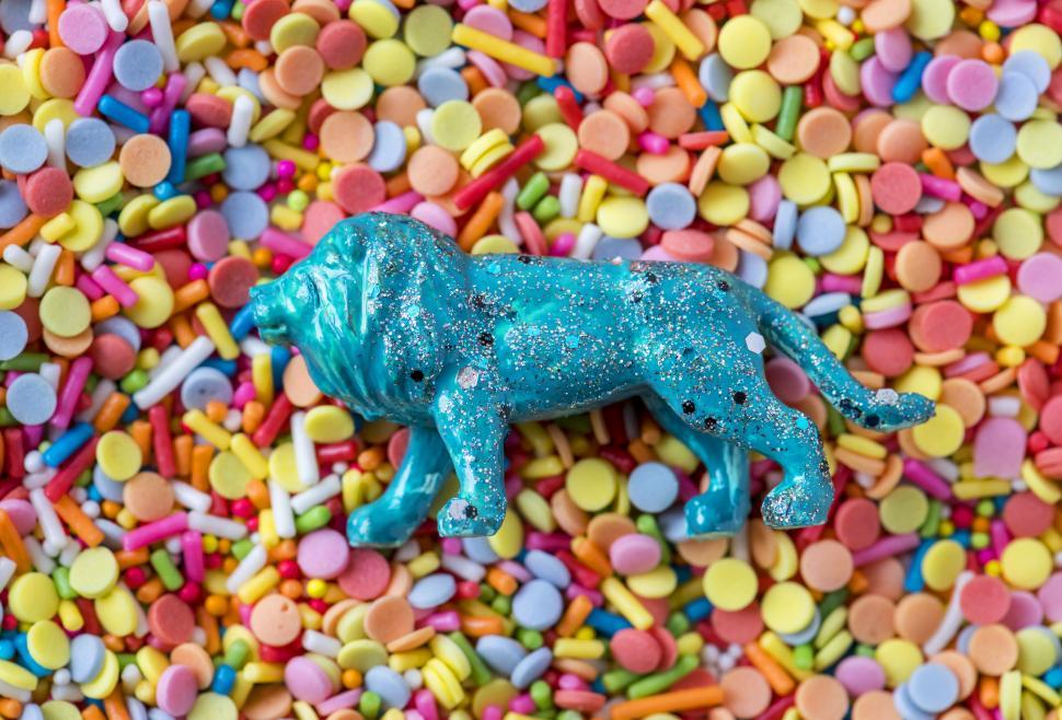 Free Image of Flat lay of a glittery toy lion on candy balls 