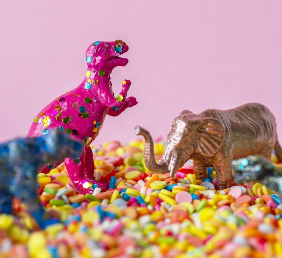 Free Image of Close up of a glittery toy elephant and dinosaur on candy balls 