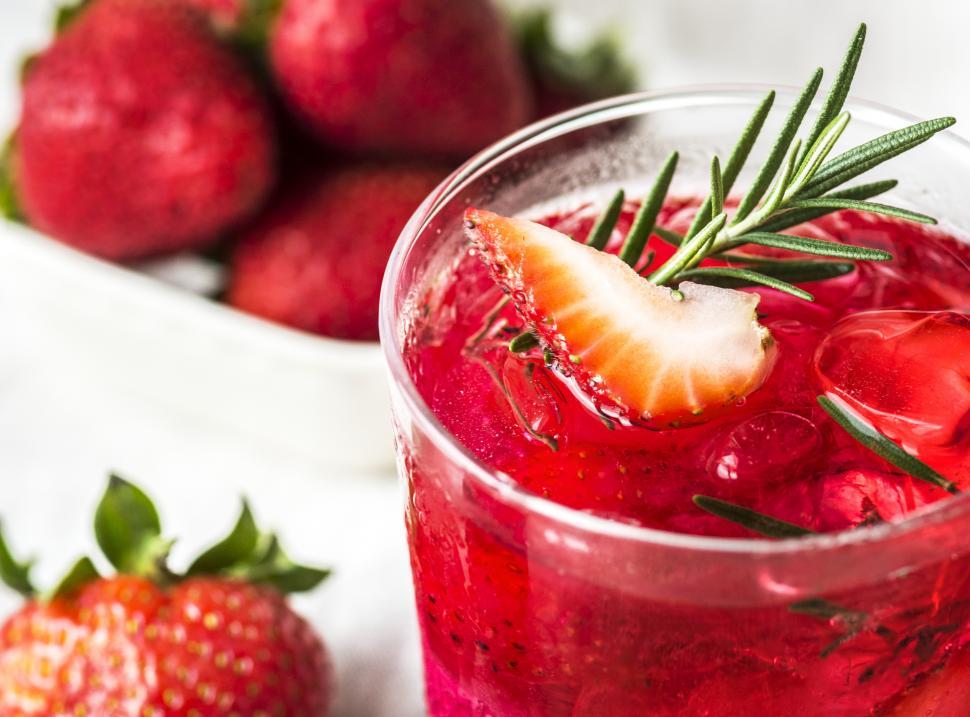 Free Image of Close up of chilled beverage garnished with strawberry and rosemary leaves 