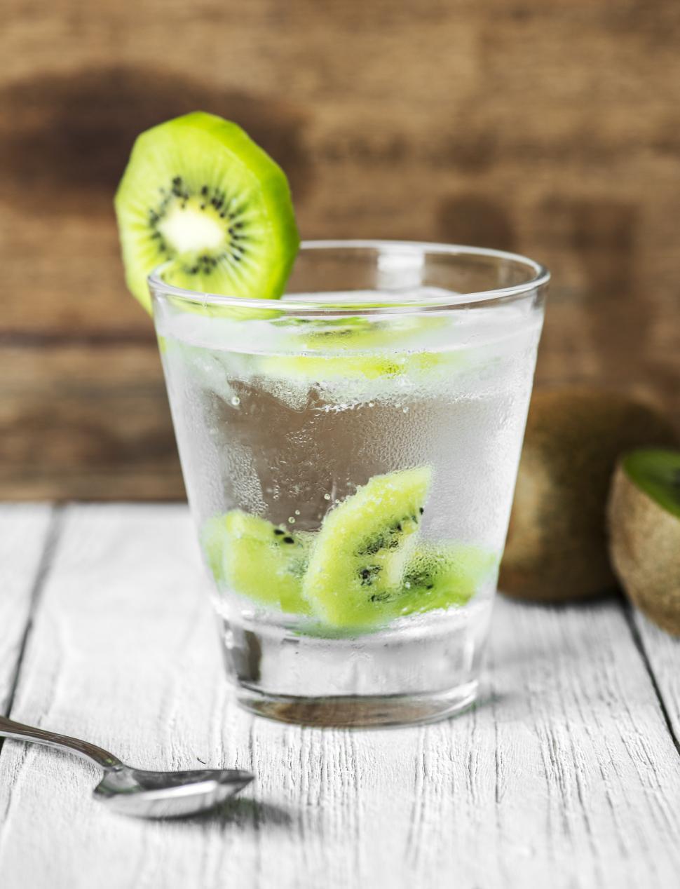 Free Image of Close up of a clear glass of beverage garnished with kiwi slices 