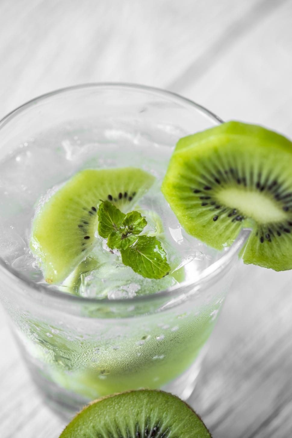 Free Image of Close up of a glass of chilled beverage garnished with kiwi slices 