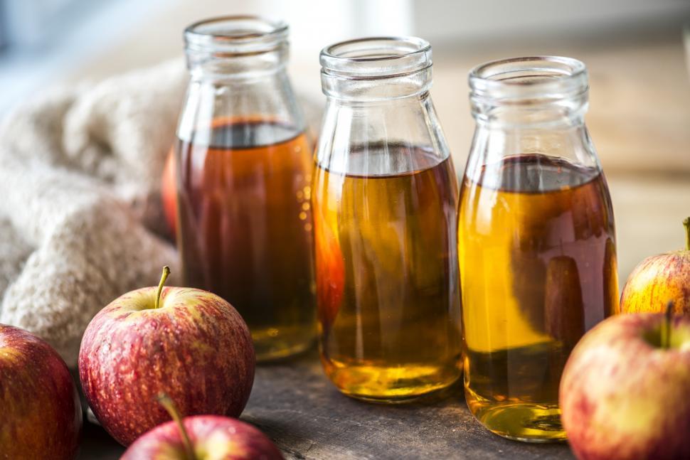 Free Image of Close up of apple juice bottles and apples 