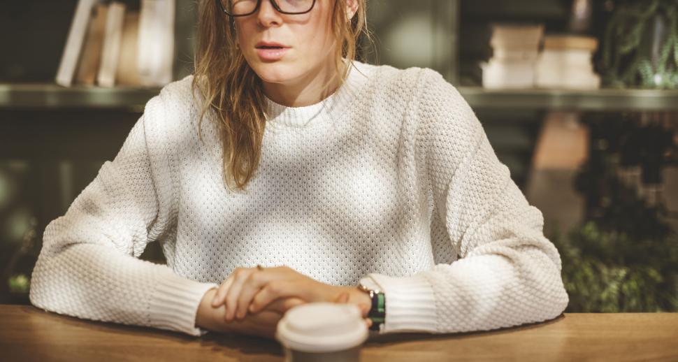 Free Image of A young Caucasian woman enjoying coffee at a cafe 