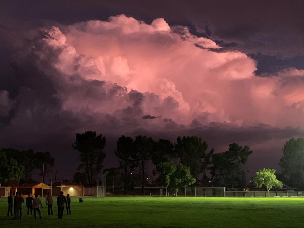 Free Image of Storm Clouds Glow over Green Grass 