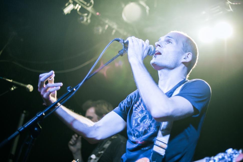 Free Image of Man Singing Into Microphone at Concert 