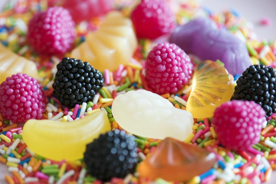 Free Image of Hard fruit candies on rainbow candy sprinkles 