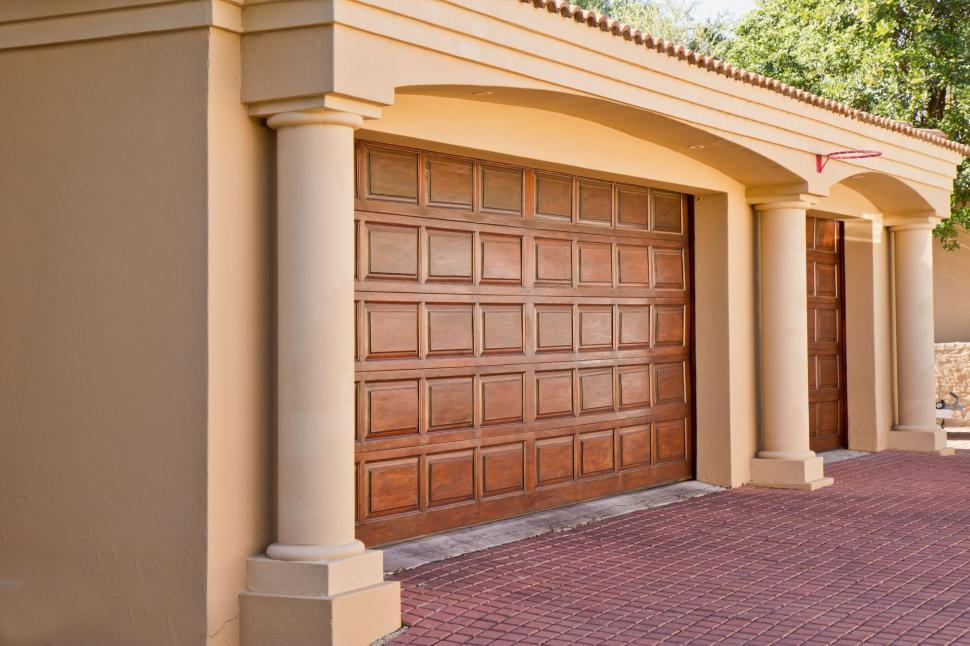 Free Image of Residential House With Brick Driveway and Brown Garage Door 
