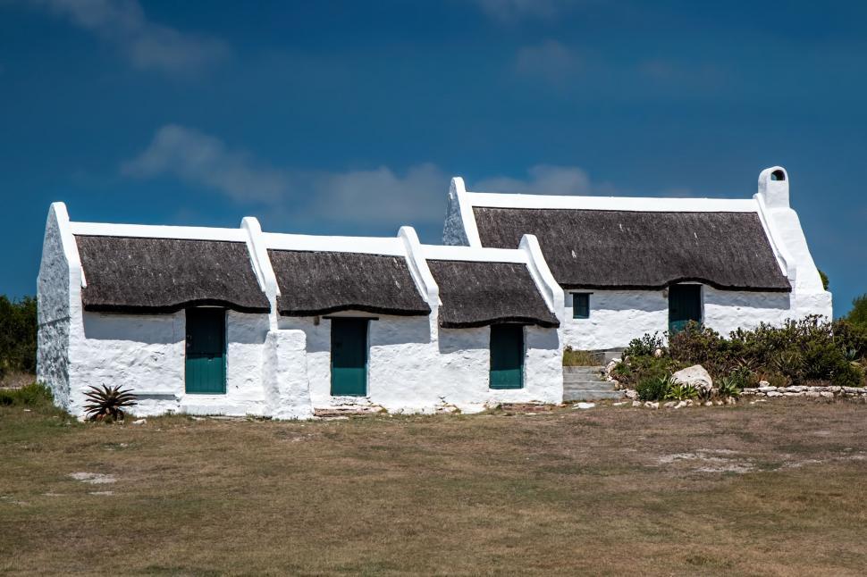 Free Image of White Building With Thatched Roof and Three Windows 