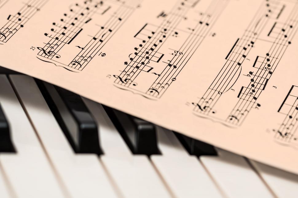 Free Image of Sheet Music on Top of Piano Keyboard 
