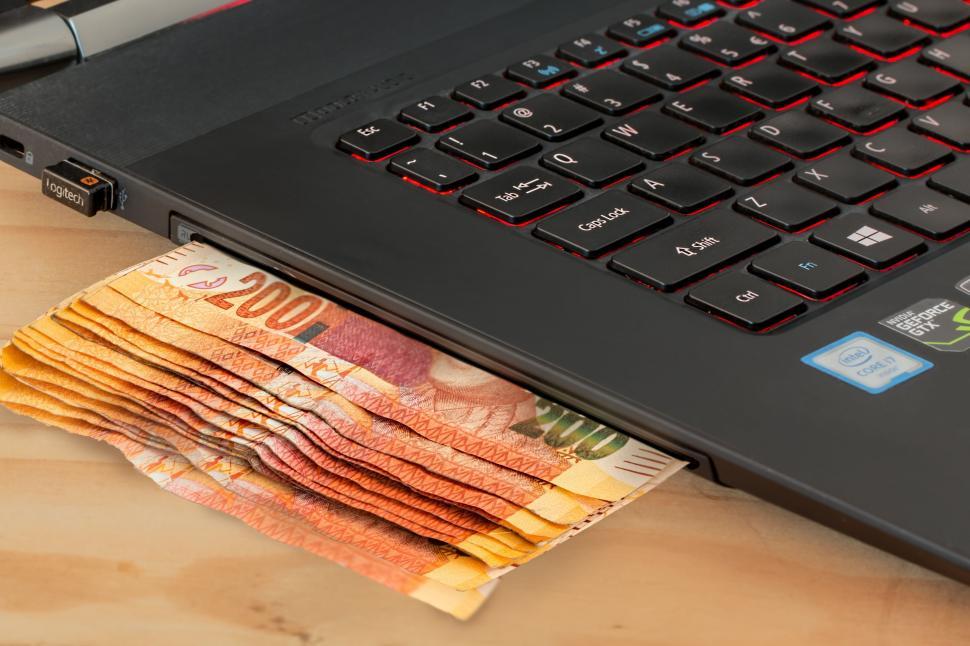 Free Image of Stack of Money on Laptop Computer 