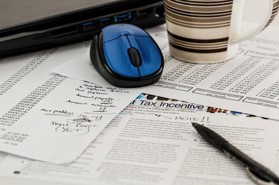 Free Image of Computer Mouse on Pile of Tax Paperwork 