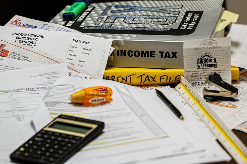 Free Image of Stack of Papers and Calculator on Desk 