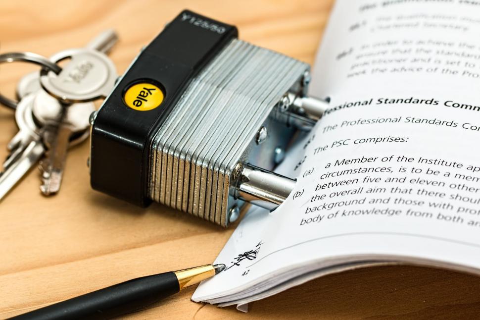 Free Image of Padlock and Keys Next to a Book on a Table 