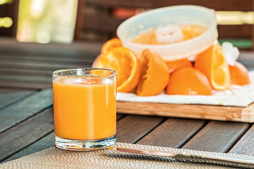 Free Image of A Glass of Orange Juice on a Wooden Table 
