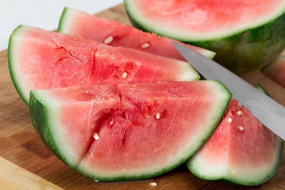 Free Image of Cut Up Watermelon on Cutting Board With Knife 