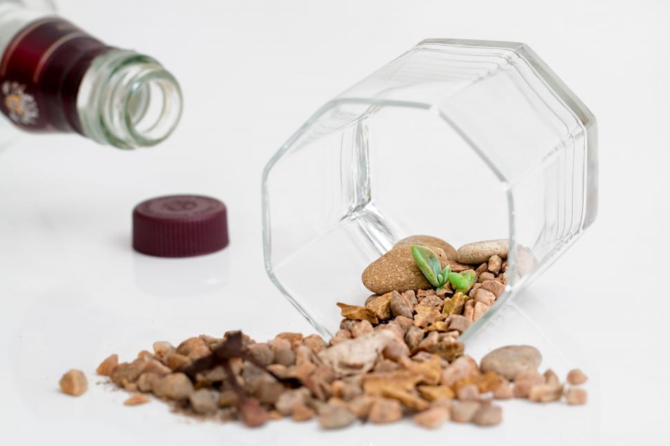 Free Image of Glass Bottle Filled With Food Beside Pile of Rocks 