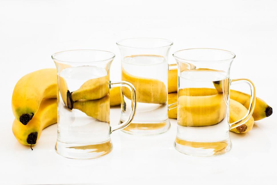 Free Image of Bunch of Bananas Next to Glass of Water 