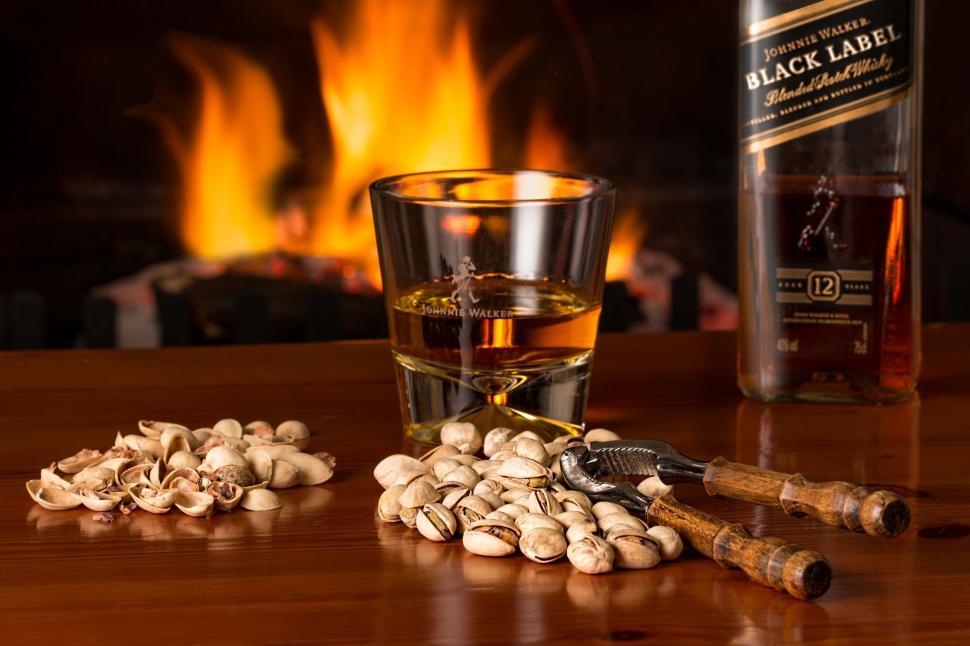 Free Image of whisky fireside alcohol beverage glass liquor pistachios flames fireplace nuts drink 