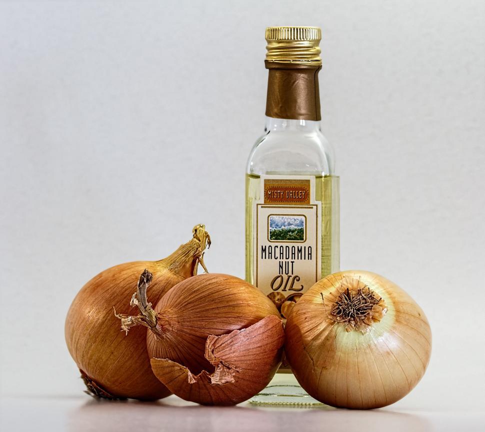 Free Image of Three Onions and a Bottle of Vinegar on a White Surface 