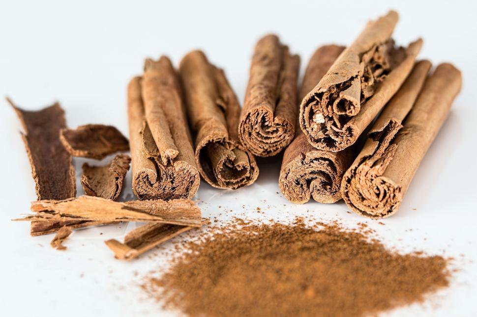 Free Image of A Pile of Cinnamon Sticks Next to Cinnamon Powder 