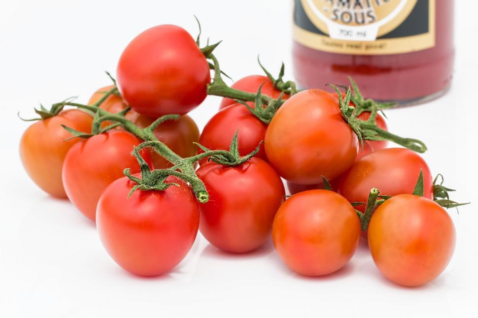 Free Image of Pile of Tomatoes Next to Jar of Tomato Sauce 