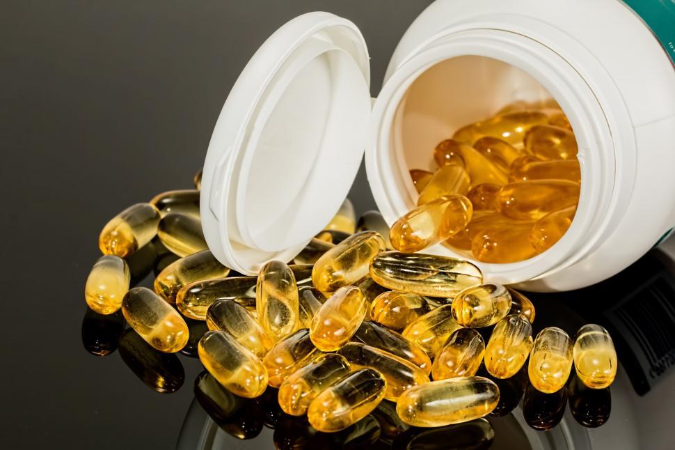 Free Image of Fish Oil Capsules Spilling Out of a Container 