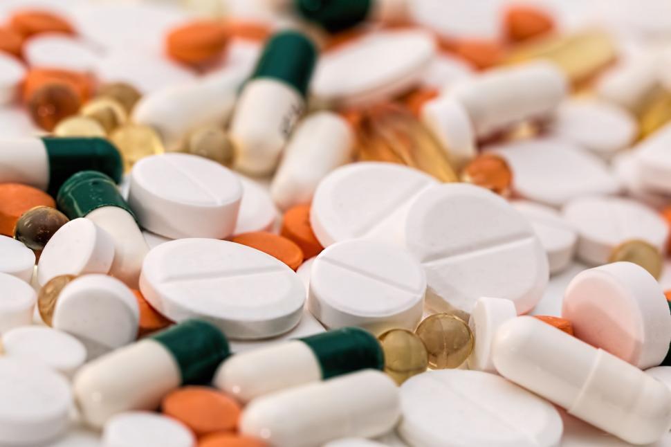 Free Image of Stack of White and Orange Pills and Capsules 