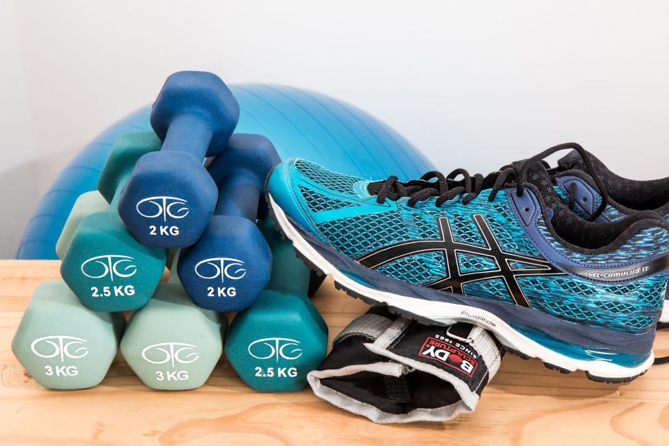 Free Image of Running Shoes Next to Dumbbells in Close-Up 