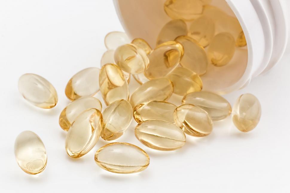 Free Image of Fish Oil Capsules Spilling Out of a Container 